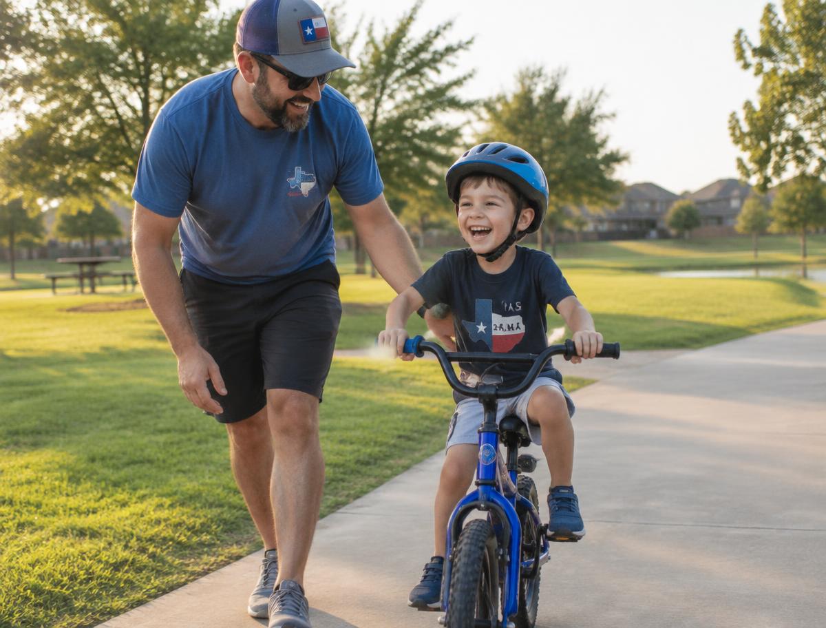 A dad helping his son learn to ride a bike in the park
